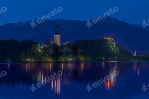 Preview: Village church and buildings reflected in still lake at night, Bled, Upper Carniola, Slovenia