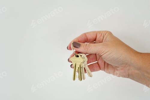 Preview: Female hand holding a set of keys, minimal - new home or office, real estate, investment opportunity