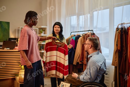 Preview: Young Black Man Showing Second Hand Sweater to Caucasian Man with Disability