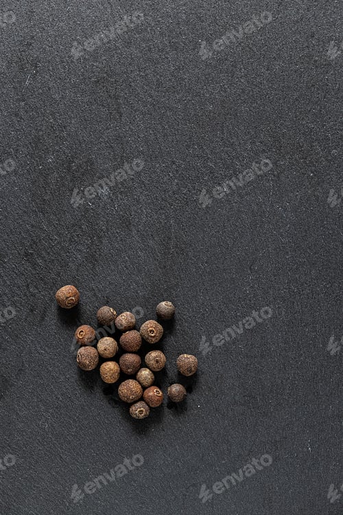 Preview: Black peppercorns and ground pepper on dark background