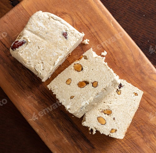 Preview: Halva almond nuts slices on wooden table background
