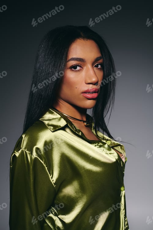 Preview: Brunette beauty in a green silk shirt striking a pose in a modern studio setting