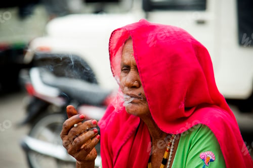 Preview: Old age woman smoking Indian handmade cigarette.