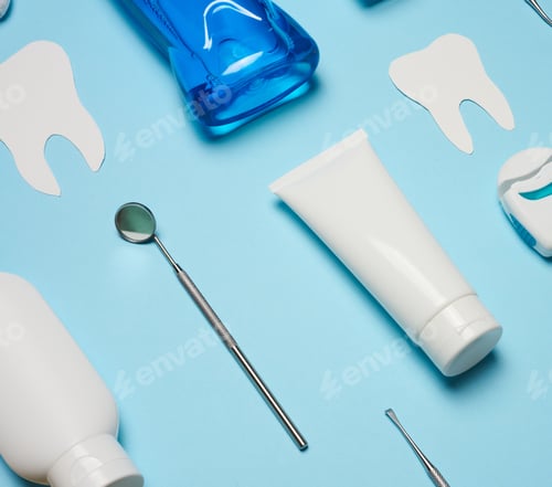 Preview: Mouthwash, toothpaste tube, dental floss and medical mirror on a blue background, oral hygiene.
