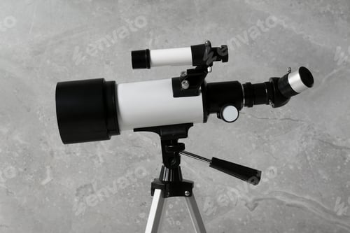 Preview: Tripod with modern telescope near grey wall, closeup