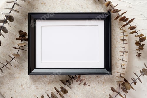 Preview: top view blank black photo frame mockup with eucalyptus brancch at peach wall