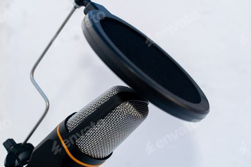 Preview: Closeup of a black and grey microphone on a white surface and background