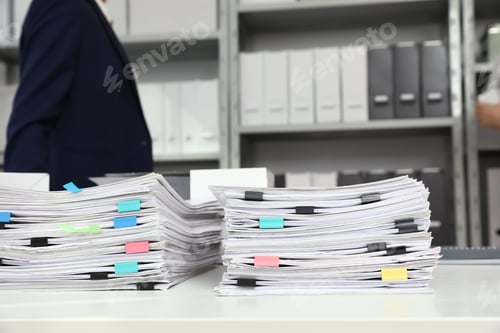 Preview: Stacks of documents with paper clips on office desk