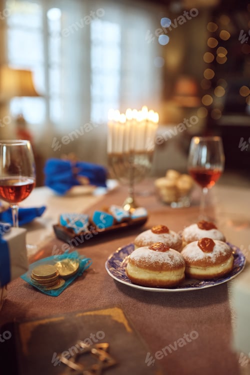 Preview: Traditional table setting with sufganiyah donuts during Hanukkah celebration.