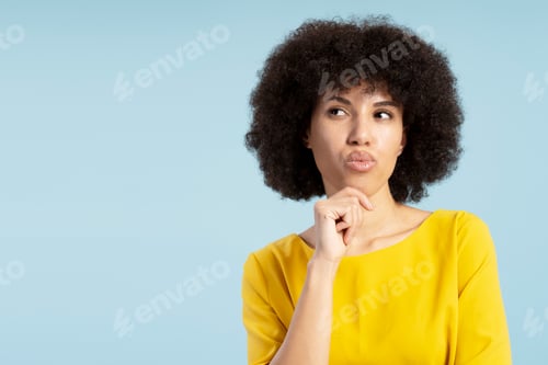 Preview: Pensive young African American woman pondering a decision on blue background