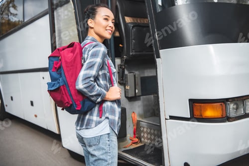 Preview: asian young woman with rucksack walking into travel bus at street