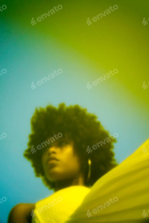 Preview: Neon portrait Low angle of the beautiful black woman with Afro hair against blue sky
