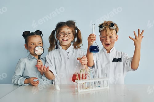 Preview: Happy friends smiling. Children in white coats plays a scientists in lab by using equipment
