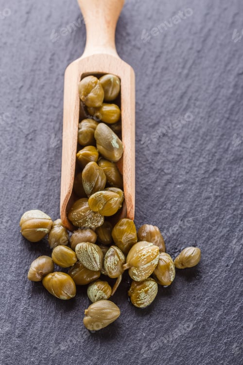 Preview: pickled capers on a dark stone background