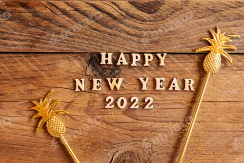 Visualização: texto de madeira de feliz ano novo 2022 decorado com palitos de abacaxi dourados para bebidas. Festivo tropical