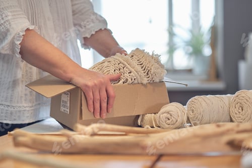 Preview: woman entrepreneur packs a handmade product in a cardboard box. delivery of goods for