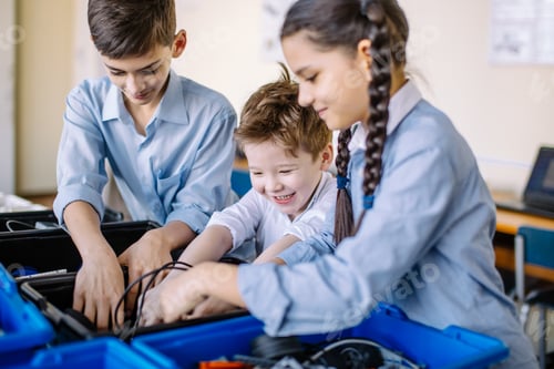 Preview: Group of kids choose parts of robotic toys for building robots at school lesson