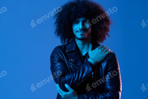 Preview: Portrait of fashion man with curly hair on blue background multinational, colored light, black