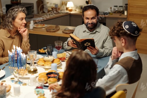 Preview: Happy bearded man with open Scripture sitting in front of his family