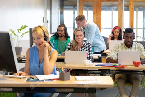 Preview: Front view of diverse customer service executives working at desk in a modern office