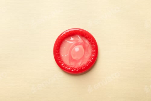 Preview: Single red condom on beige background, top view