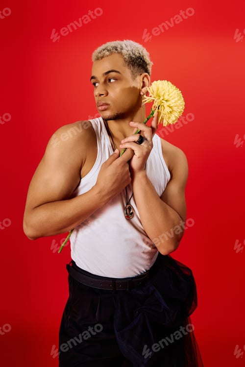Preview: Handsome young man displays vibrant style in trendy red studio setting