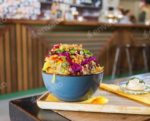 Preview: Closeup of a dish with potatoes, meat, and sliced vegetables in a bowl with a blurred background