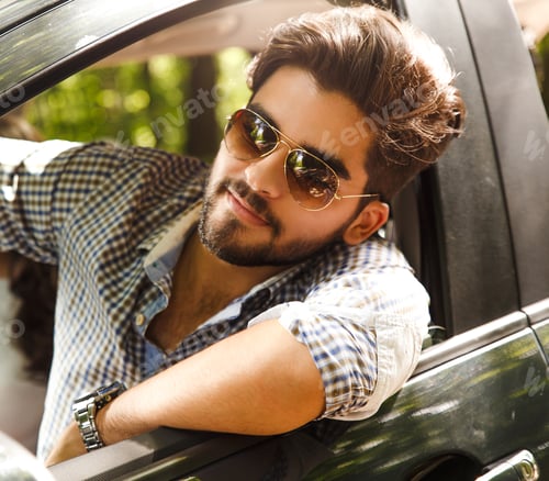 Preview: Portrait of young man in car looking out the window.