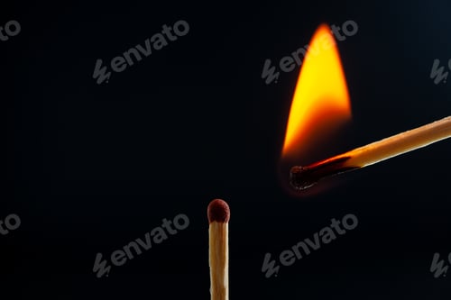 Preview: Top view of lighting one match to another one on dark background