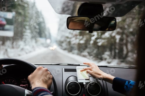 Hands of couple driving and using navigation on mobile phone