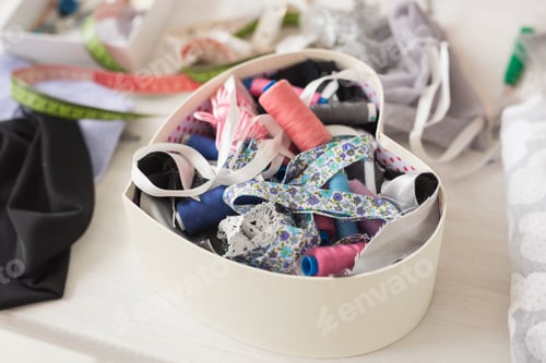 Preview: Industry and fashion concept - Close up portrait of sewing thread in heart-box and sewing