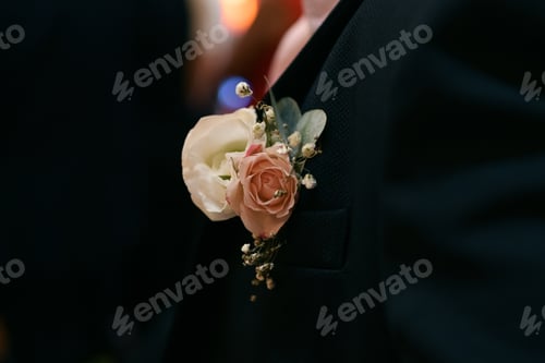Preview: Groom at a wedding with a boutonniere of white gypsophila and rose
