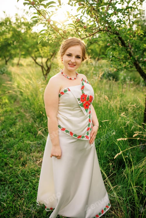 Preview: Young girl at ukrainian national dress posed at spring garden.