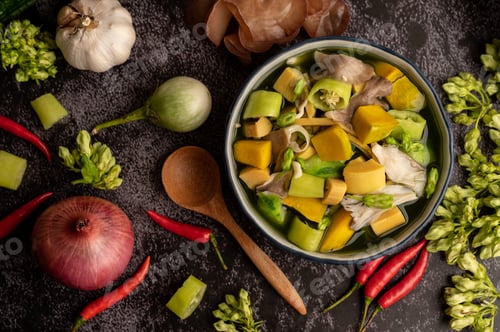 Preview: Kaeng Liang in a bowl with spices on a black cement floor.