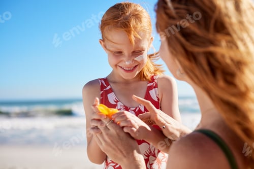 Preview: Lovely mother applying sunscreen on cute little girl on cheeks