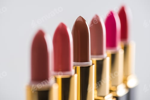 Preview: close up view of assorted lipsticks in luxury tubes in line isolated on white background