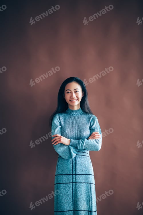 Preview: Portrait of happy asian woman with crossed arms