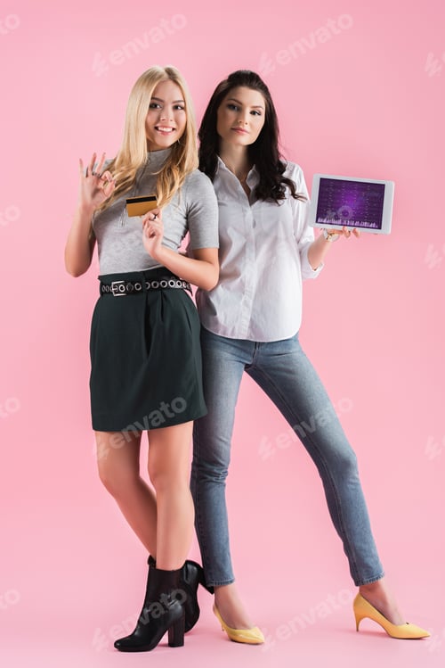Preview: Young women holding credit card and digital tablet with infographic app on screen and showing okay