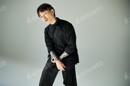 Preview: Stylish young man showcasing contemporary fashion in a minimalist studio setting
