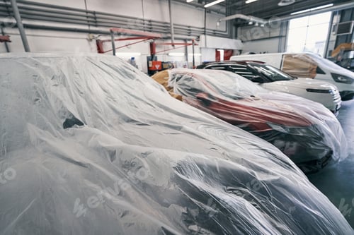 Preview: Cars standing in line with dustsheets on them