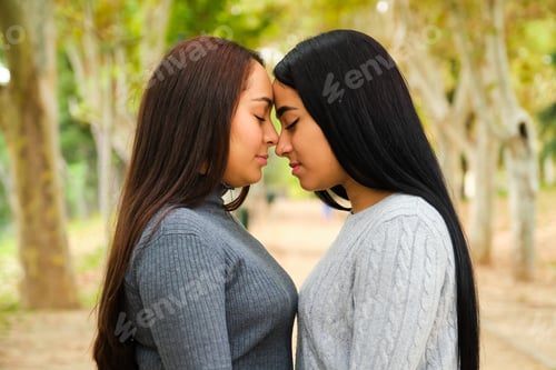 Preview: Latin lesbian couple in love in a park in autumn.