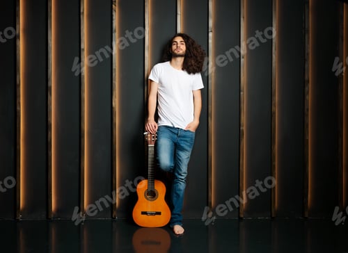 Preview: Full Length Shot Of Musician Man Holding Guitar In Studio