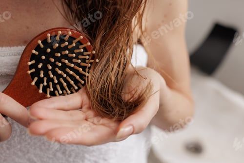 Preview: Close-up woman brushing damp hair with wooden brush, beauty haircare and wellness grooming concept.