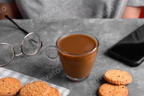 Preview: a transparent cup of coffee with milk in the kitchen table
