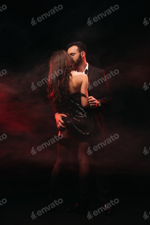 Preview: attractive passionate couple hugging in red smoky room