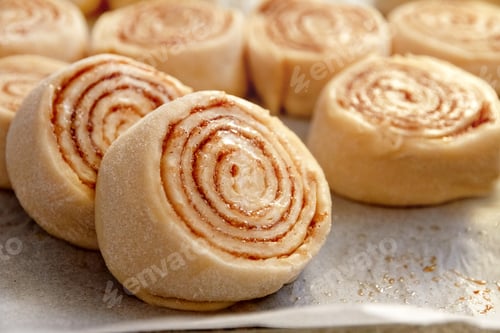 Preview: Dough buns lie on baking sheet and are ready for baking on row baking paper side view, close up