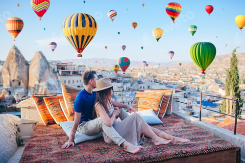 Preview: Happy young couple during sunrise watching hot air balloons in Cappadocia, Turkey
