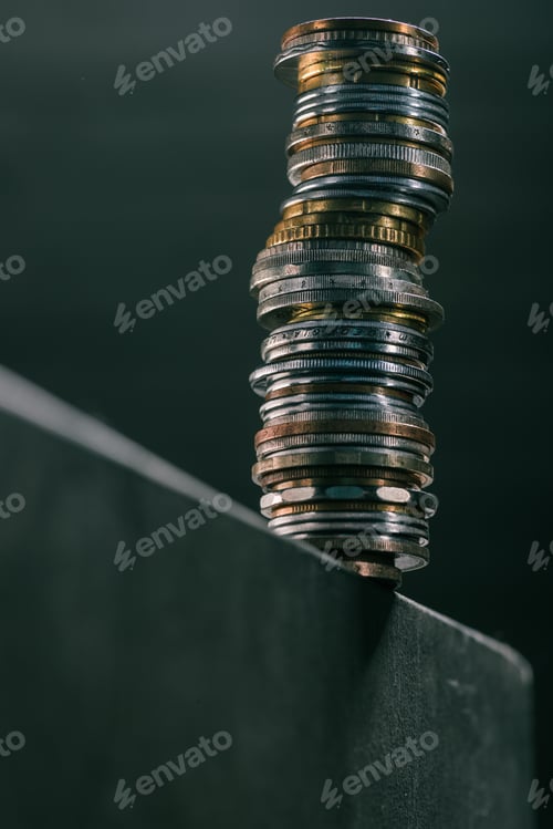 Preview: close up view of stack of different coins standing on edge of table