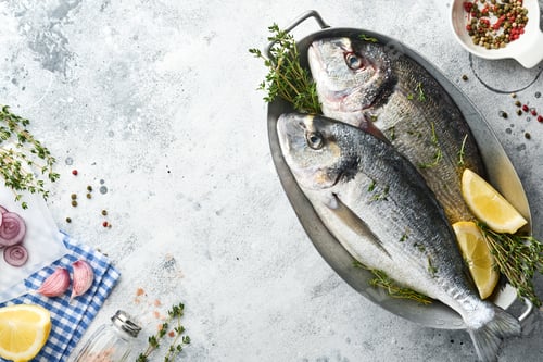 Preview: Raw dorado fresh fish or sea bream with ingredients for making lemon, thyme, garlic, cherry tomato a