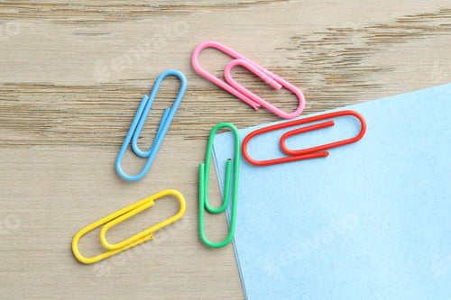 Preview: Many colorful clips and paper notes on wooden table, flat lay